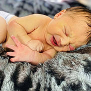 Grayson is registered to the contest to win money with this photo: baby, blanket, closeup, cute, expression, face, fingers, fur, hand, infant, lying_down, natural_light, newborn, peaceful, rest, skin, sleeping, small, soft, texture