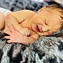Grayson is registered to the contest to win money with this photo: baby, newborn, infant, blanket, soft, cute, sleeping, face, skin, hand, fingers, fur, texture, lying_down, expression, small, peaceful, rest, closeup, natural_light