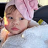 Elif is registered to the contest to win money with this photo: baby, child, infant, car_seat, pink_bow, headband, white_jacket, fluffy_clothing, portrait, face, eyes, rosy_cheeks, curious_expression, natural_light, indoor, car_interior, seatbelt, earrings, closeup, young