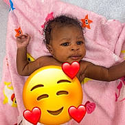 Keziah is registered to the contest to win money with this photo: baby, infant, diaper, pink_blanket, stars, fish, curly_hair, lying_down, indoor, cute, child, smiling_emoji, hearts, soft_texture, playful, skin, expression, colorful, comfort, young_child