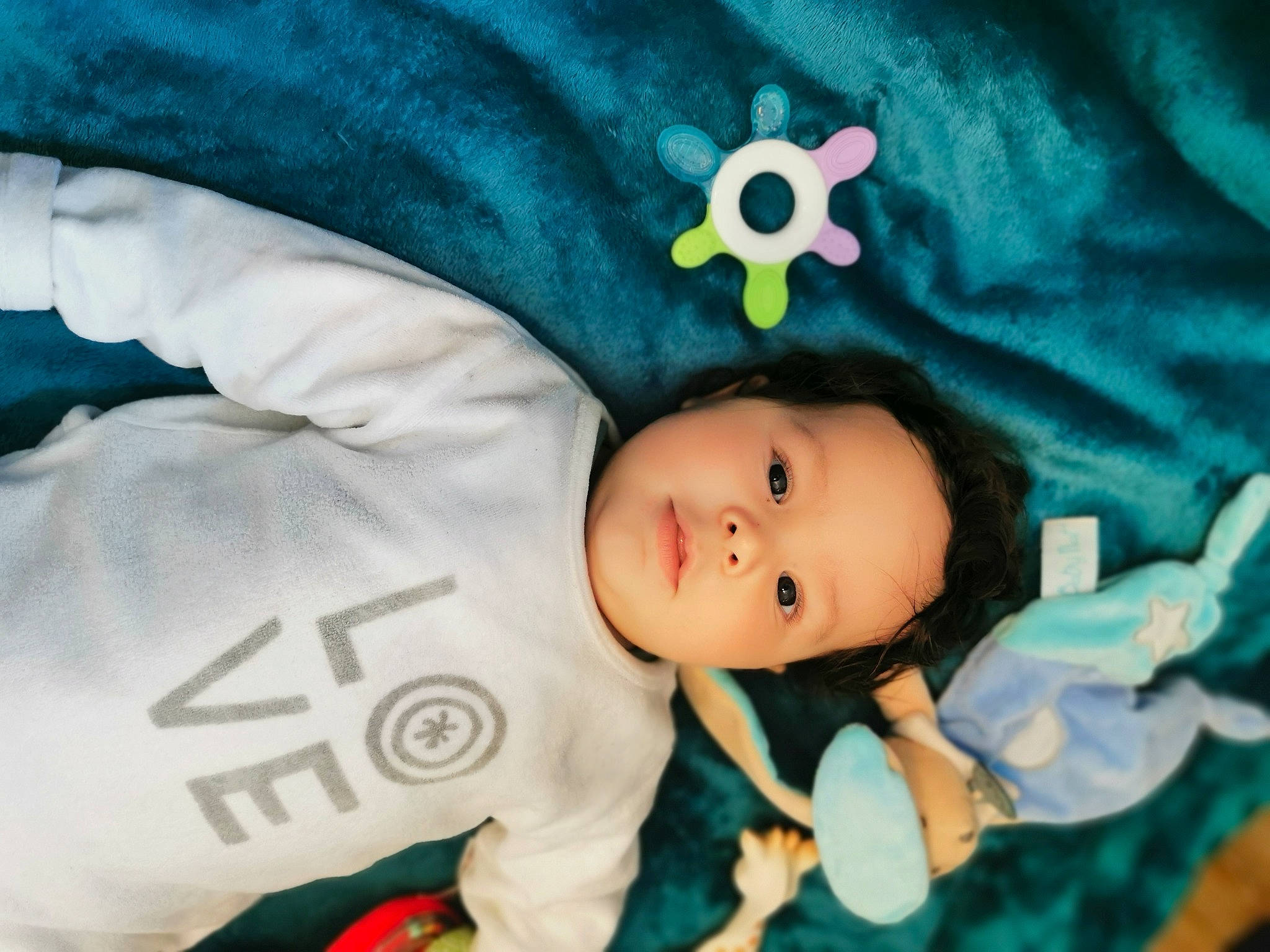 Madi a rejoint le concours — aidez-le/la à gagner de superbes lots ! baby, baby_products, baby_toddler_clothing, cheek, child, comfort, doll, face, happy, human_body, pattern, person, plush, sitting, sleeve, smile, stuffed_toy, textile, toddler, toy