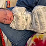 baby, newborn, sleeping, swaddle, elephant_print, denim, jeans, lap, blanket, red, tie_dye, fabric, clothing, person, infant, resting, indoor, portrait, cute, peaceful