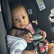 Shiloh joined the competition — help win amazing prizes! baby, child, car_seat, infant, seatbelt, harness, blanket, clothing, person, face, hand, sitting, indoors, cute, looking_at_camera, curious, safety, transportation, young_child, toddler