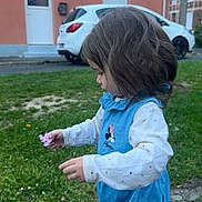 Ysaïnna participe au concours pour gagner de l'argent avec cette photo : child, toddler, girl, flower, grass, blue_clothing, outdoor, house, car, side_view, curly_hair, long_sleeves, minnie_mouse, nature, daylight, side_profile, young_child, curiosity, small_flower, casual_wear