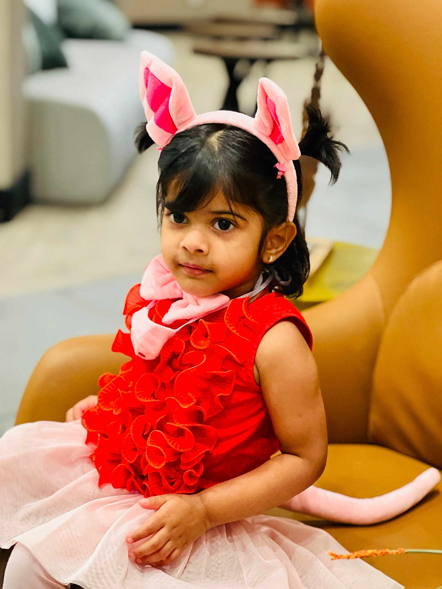 Thiya Tahkshi joined the competition — help win amazing prizes! child, girl, pink_ears, pink_tail, red_dress, ruffles, tutu, chair, indoor, portrait, cute, costume, playful, young, fashion, smile, seated, curious, person, home