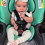 Vanessa is registered to the contest to win money with this photo: baby, car_seat, headband, flower, infant, child, seatbelt, pink_socks, white_pants, short_sleeve_shirt, warning_label, indoor, curious, cute, sitting, child_safety, soft_lighting, car_seat_pillow, baby_girl, seated