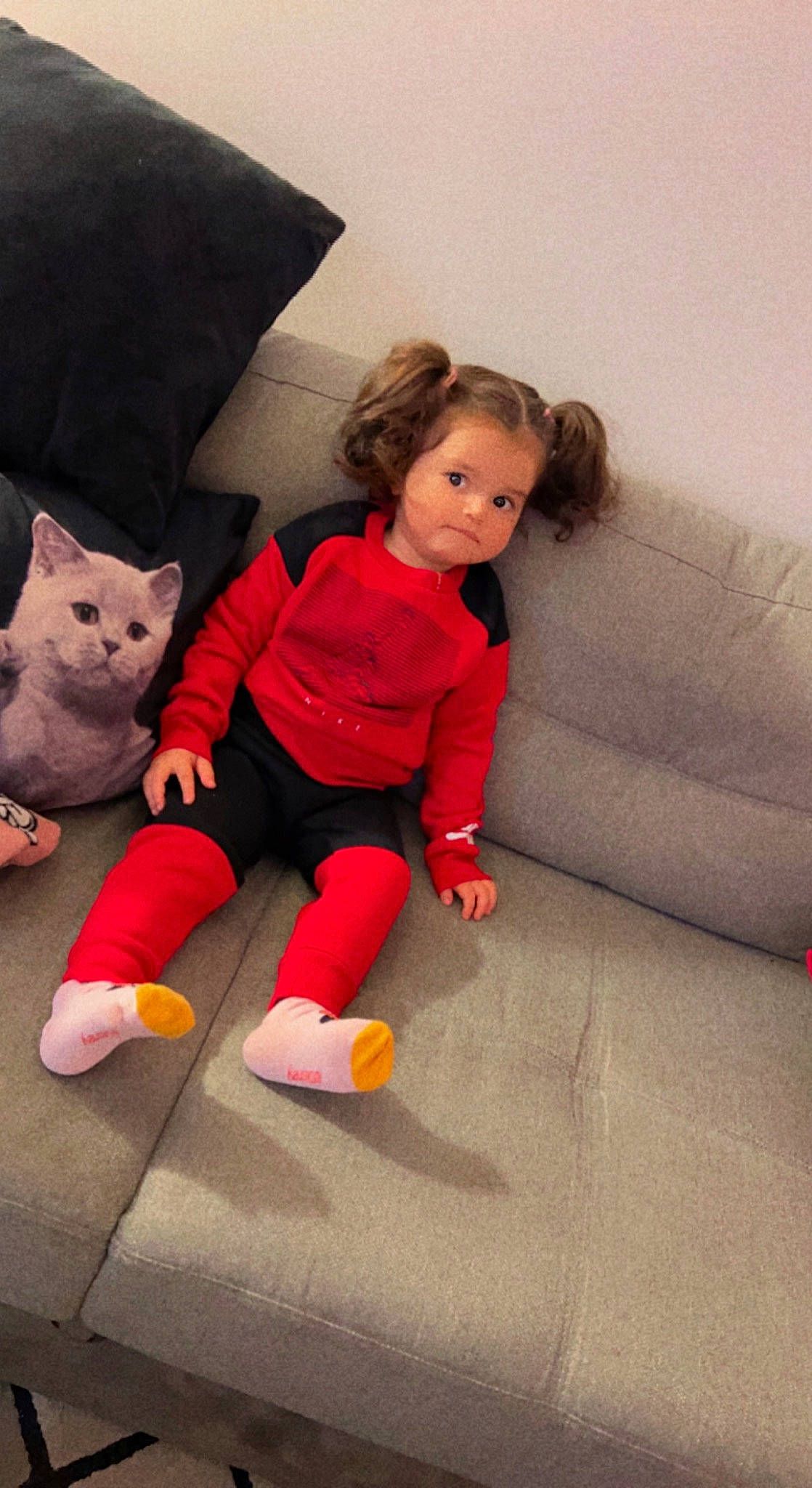 Lyana participe au concours pour gagner de l'argent avec cette photo : child, comfort, couch, facial_expression, felidae, floor, flooring, foot, fun, gesture, human_body, human_leg, lap, leg, person, pink, skin, sock, textile, toddler