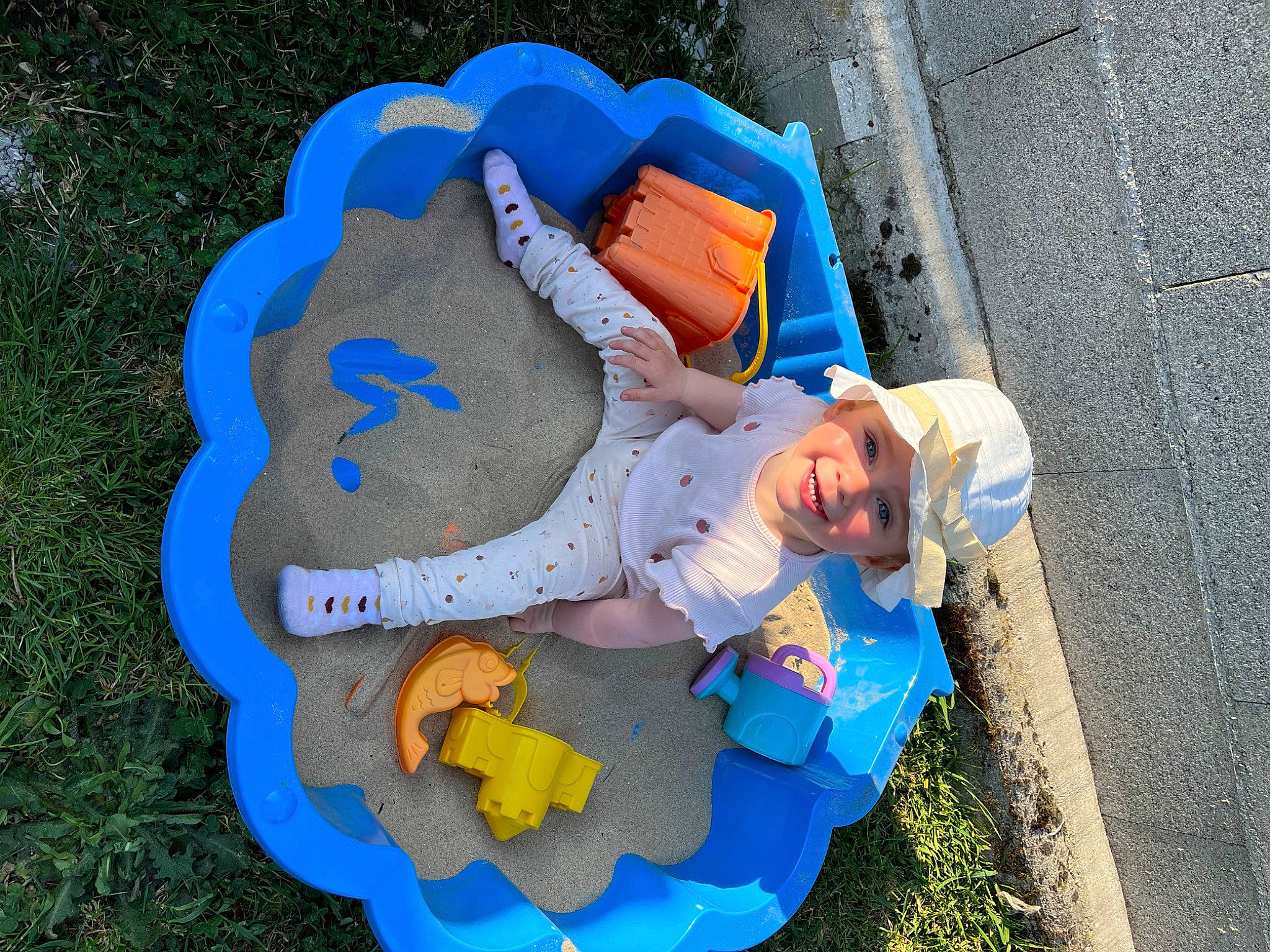 Mya a rejoint le concours — aidez-le/la à gagner de superbes lots ! asphalt, azure, child, circle, concrete, electric_blue, fashion_accessory, font, fun, grass, headwear, joy, landscape, leisure, person, play, recreation, road_surface, sidewalk, sitting