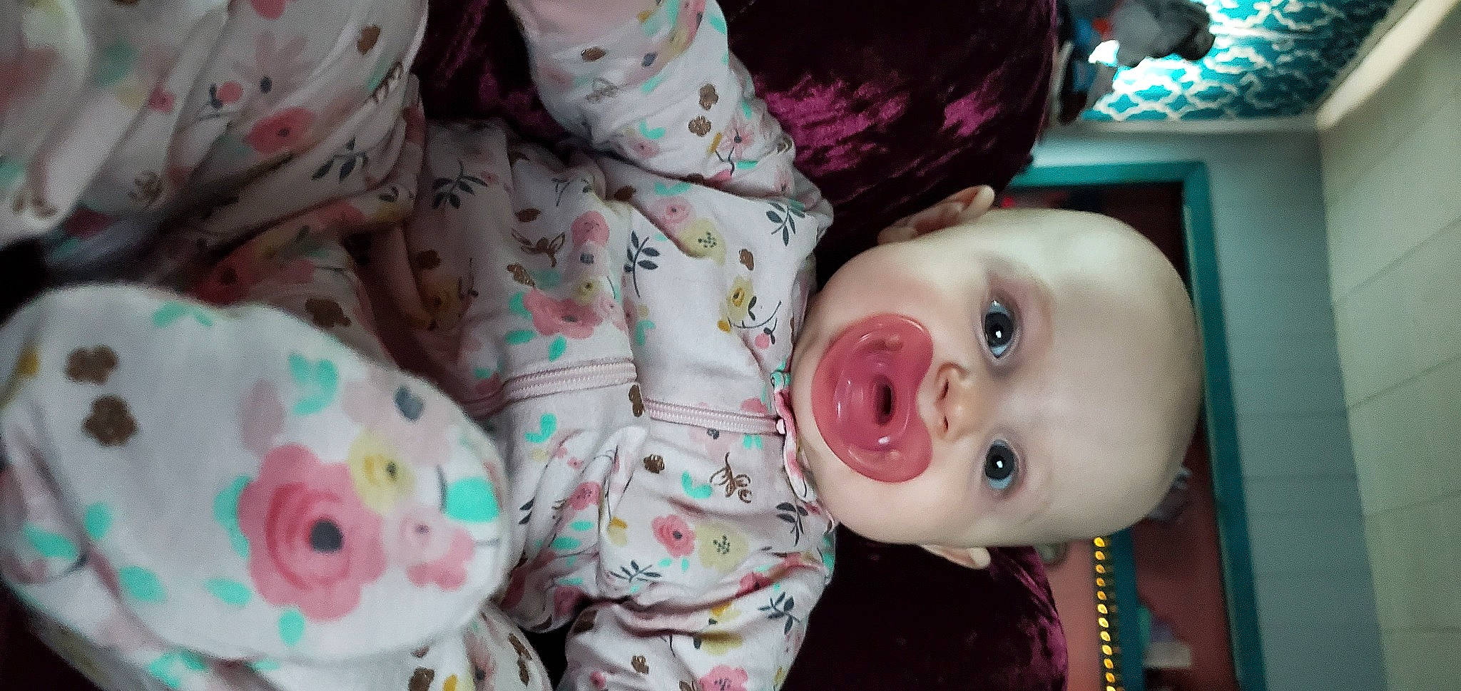 Saphira is registered to the contest to win money with this photo: baby, baby_toddler_clothing, cheek, child, eye, eyelash, facial_expression, happy, linens, mammal, mouth, nose, pattern, person, pink, skin, smile, textile, toddler, toy