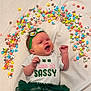 Paisley joined the competition — help win amazing prizes! baby, infant, smiling, headband, tutu, green, cereal, colorful, blanket, clothing, cute, happy, lying_down, indoors, playful, toddler, face, expression, small_hands, cheerful