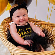 Paisley joined the competition — help win amazing prizes! baby, infant, basket, balloons, black_headband, black_outfit, gold_text, smiling, celebration, half_birthday, cute, happy, indoor, wicker, tulle_skirt, headband, child, portrait, decorations, soft_fur_rug