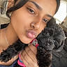 woman, puppy, dog, pet, indoor, selfie, affection, cute, black_dog, striped_shirt, nose_ring, hand, window, bed, blanket, jewelry, casual, young_adult, portrait, love