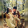 family, baby, woman, man, smile, outdoor, forest, autumn, sweater, jacket, baby_clothing, nature, sunlight, happy, people, parent, child, warm_clothing, trees, blurred_background