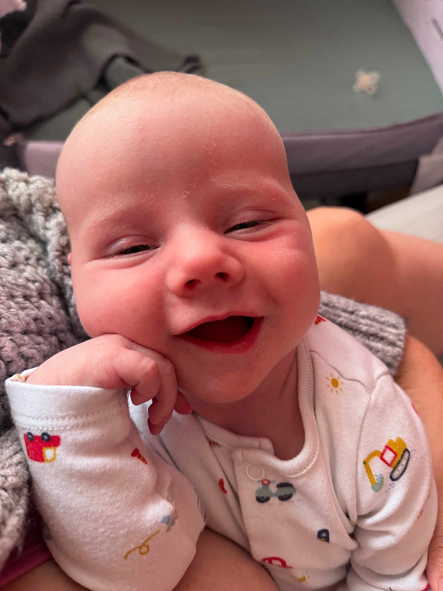 Jenson-James joined the competition — help win amazing prizes! baby, smiling, infant, onesie, hand, face, cheek, knitted_blanket, cozy, cute, happy, person, child, portrait, sitting, skin, head, clothing, indoor, closeup