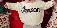 Jenson-James joined the competition — help win amazing prizes! baby, infant, sweater, name, jenson, plush_toys, blanket, red_blanket, pillow, patterned_pillow, socks, feet, smiling, lying_down, cute, indoor, child, soft_toys, cozy, happy