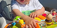 Yonie participe au concours pour gagner de l'argent avec cette photo : baby, cap, child, colorful, curious, cute, daylight, face, hand, hat, outdoor, person, plastic, play, seat, sunlight, toddler, toy, walker, young