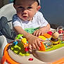 baby, cap, child, colorful, curious, cute, daylight, face, hand, hat, outdoor, person, plastic, play, seat, sunlight, toddler, toy, walker, young