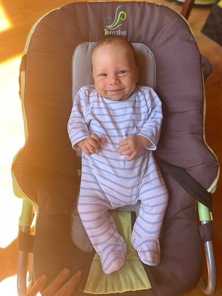 Lou participe au concours pour gagner de l'argent avec cette photo : baby, baby_products, baby_toddler_clothing, car_seat, child, comfort, flooring, fun, happy, joy, knee, laugh, linens, person, room, sitting, skin, sleeve, smile, sock