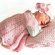 Charlie a rejoint le concours — aidez-le/la à gagner de superbes lots ! newborn, baby, sleeping, pink, crocheted_blanket, hat, flower, pillow, cozy, resting, infant, cute, soft_texture, smile, peaceful, portrait, child, white_background, hand, clothing