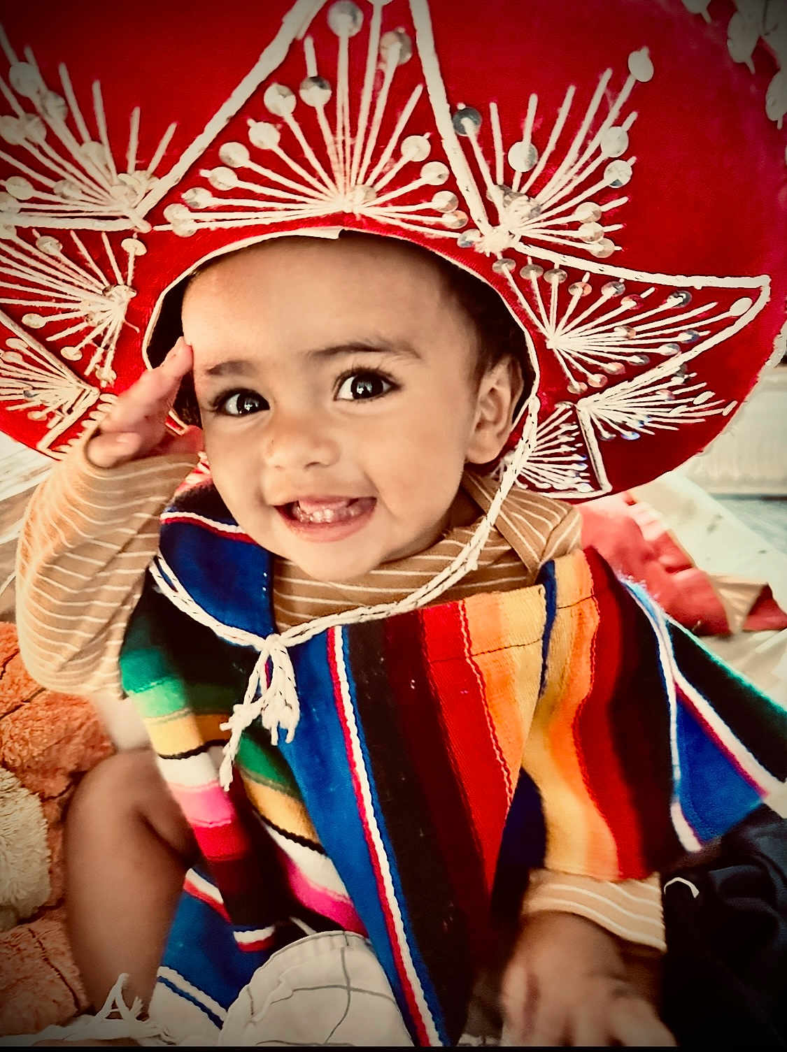 Emmanuel Mendoza is registered to the contest to win money with this photo: toddler, child, smiling, sombrero, colorful_poncho, saluting, happy, face, clothing, indoor, cute, portrait, baby, bright_colors, hat, cheerful, playful, candid, person, celebration