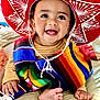 Emmanuel Mendoza joined the competition — help win amazing prizes! baby, child, smiling, sombrero, hat, colorful_clothing, poncho, striped, happy, indoors, bed, foot, hand, face, portrait, cute, infant, celebration, traditional_clothing, cultural