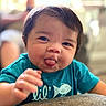 baby, blue_shirt, child, closeup, cute, expression, face, hand, happy, human, indoor, infant, person, playful, short_hair, sitting, smiling, toddler, tongue_out, young_child