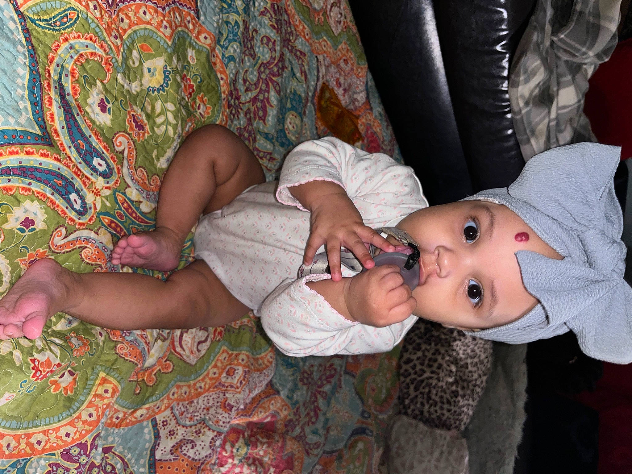 Kailani is registered to the contest to win money with this photo: baby, baby_toddler_clothing, child, comfort, finger, foot, fun, hat, headwear, human_body, human_leg, joint, lap, leg, pattern, person, room, sitting, skin, textile
