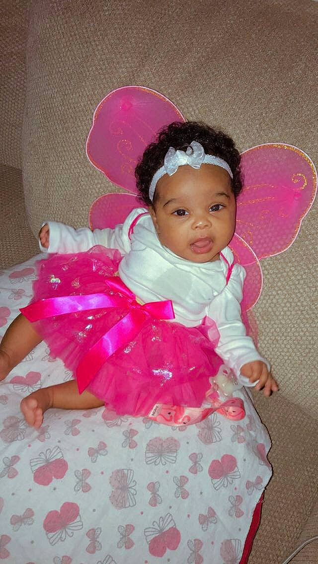 Kaidence is registered to the contest to win money with this photo: baby_toddler_clothing, cheek, dress, eye, face, happy, head, headband, headgear, headpiece, magenta, mythical_creature, person, petal, pink, product, purple, skin, sleeve, textile