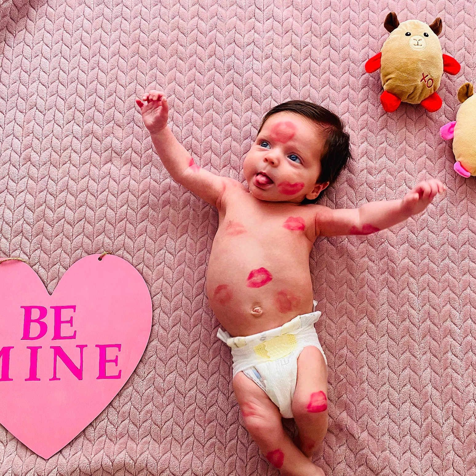 Robert Ray is registered to the contest to win money with this photo: baby, body_mark, cozy, cute, diaper, heart_sign, infant, lipstick_kisses, lying_down, nursery, pink_blanket, playful, plush_toys, portrait, smile, soft_toy, textured_blanket, tongue_out, top_view, valentine