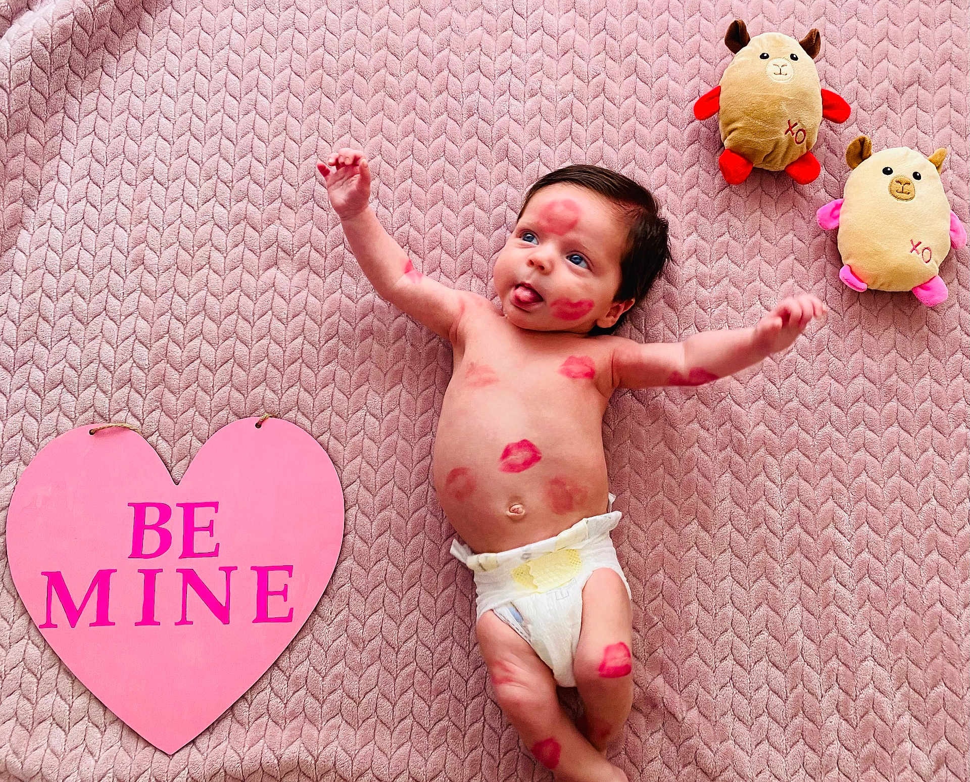 Robert Ray is registered to the contest to win money with this photo: baby, infant, diaper, lipstick_kisses, heart_sign, plush_toys, pink_blanket, textured_blanket, lying_down, tongue_out, valentine, soft_toy, cute, nursery, portrait, smile, body_mark, cozy, top_view, playful