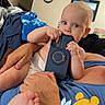 Jacob joined the competition — help win amazing prizes! baby, child, infant, portrait, smartphone, chewing, blue_eyes, blond_hair, sitting, lap, adult, blanket, winnie_the_pooh, bedroom, indoor, family, close_up, playful, feet, casual