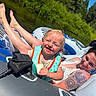 toddler, woman, inflatable_tube, river, life_vest, tattoo, sunny_day, greenery, smile, snack, outdoor, water, relaxation, summer, nature, happy, floating, family, recreation, casual