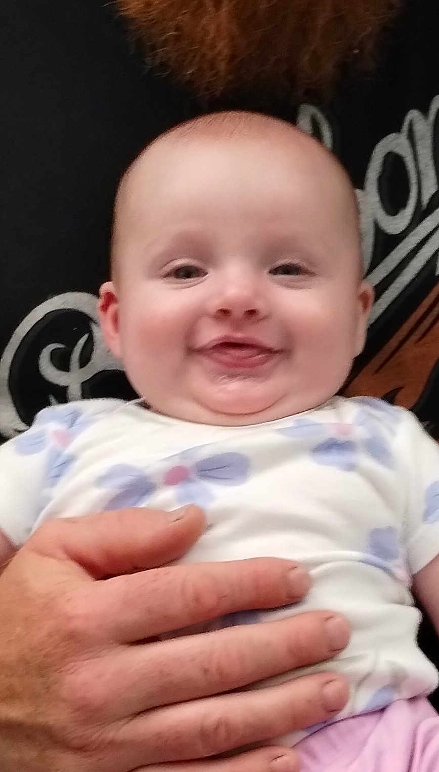 Iris joined the competition — help win amazing prizes! baby, smile, face, hand, person, infant, clothing, floral_pattern, holding, cute, portrait, skin, cheerful, young_child, closeup, expression, human, happiness, background, adult_hand