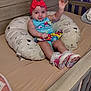 Iris joined the competition — help win amazing prizes! baby, bedroom, child, colorful_clothing, crib, cute, footwear, headband, indoors, infant, person, pillow, pink_shoes, playful, resting, sheep_pattern, smiling, waving, wooden_furniture, young_child