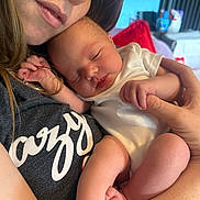 Evelyn joined the competition — help win amazing prizes! baby, sleeping, adult, holding, closeup, face, love, affection, skin, hand, white_clothing, casual_wear, indoor, couch, blanket, portrait, relaxation, comfort, peaceful, family