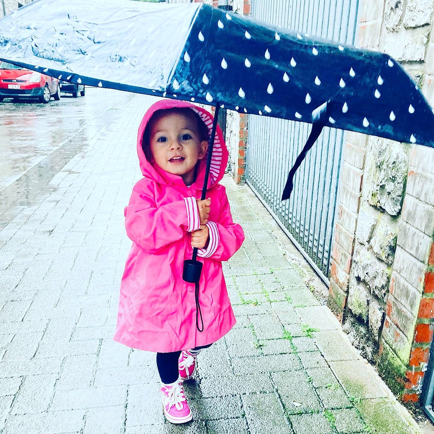 Evy participe au concours pour gagner de l'argent avec cette photo : car, child, fashion_accessory, fun, happy, headwear, jacket, leisure, magenta, pattern, person, pink, recreation, smile, street_fashion, tints_and_shades, tire, toddler, travel, umbrella