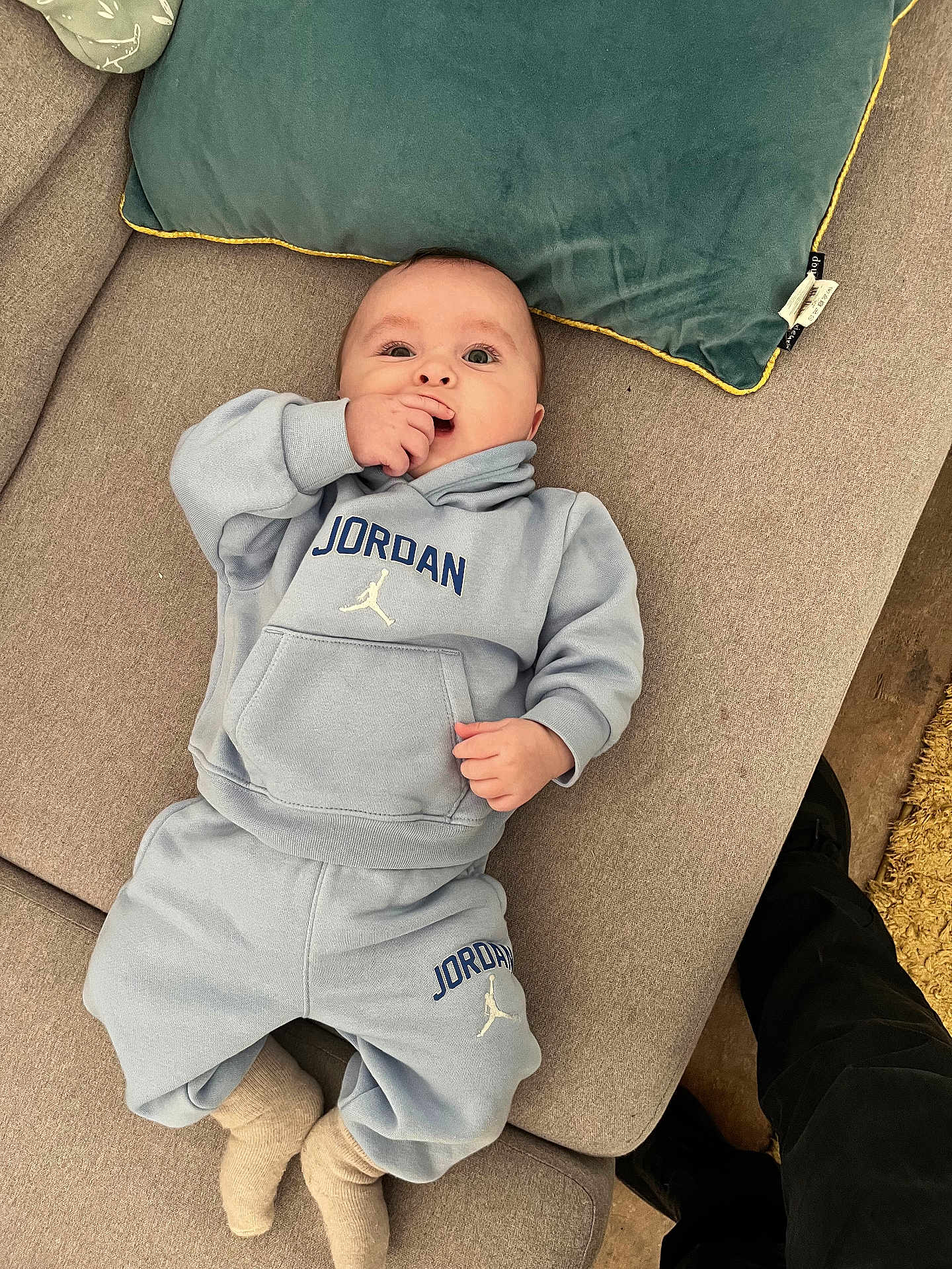 Thelio a rejoint le concours — aidez-le/la à gagner de superbes lots ! baby, child, infant, couch, pillow, clothing, blue, socks, face, hand, sitting, indoor, person, apparel, footwear, cozy, casual, portrait, relaxing, young