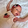 baby, infant, headband, stars, white_background, sleeveless_shirt, patriotic, heart_design, arms_outstretched, cute, lying_down, skin_detail, happy_expression, soft_texture, closeup, portrait, child, newborn, fluffy_surface, casual_clothing