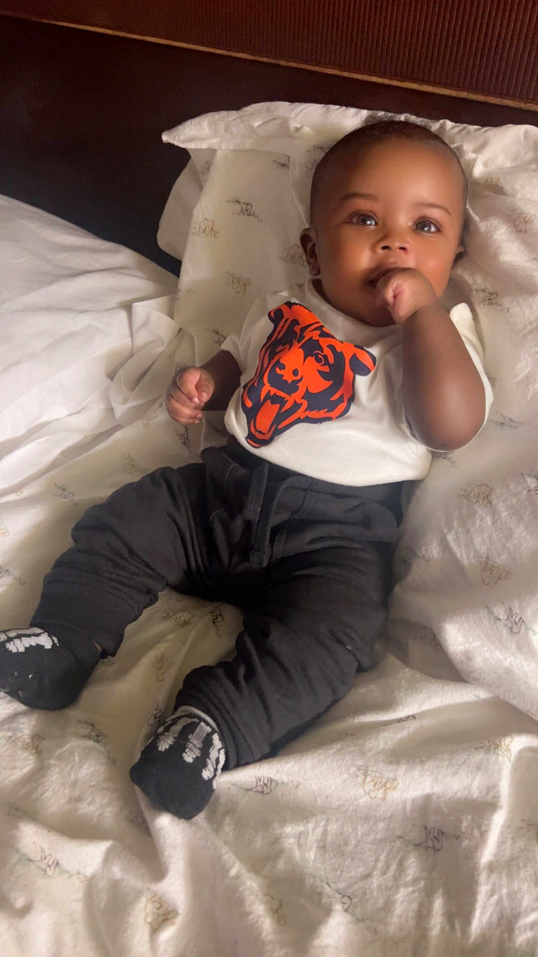 Khasson joined the competition — help win amazing prizes! baby, infant, child, bed, blanket, pillow, clothing, shirt, pants, socks, face, hand, thumb, cute, indoors, portrait, relaxed, lying_down, black_pants, white_shirt