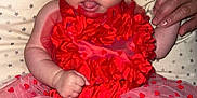 Aaliyah participe au concours pour gagner de l'argent avec cette photo : baby, infant, red_dress, flower_headband, hand_holding, cushion, star_pattern, cute, tutu_skirt, person, skin, happy, smiling, indoors, newborn, child, portrait, expression, tulle, fabric