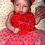 baby, child, cushion, cute, expression, fabric, flower_headband, hand_holding, happy, indoors, infant, newborn, person, portrait, red_dress, skin, smiling, star_pattern, tulle, tutu_skirt