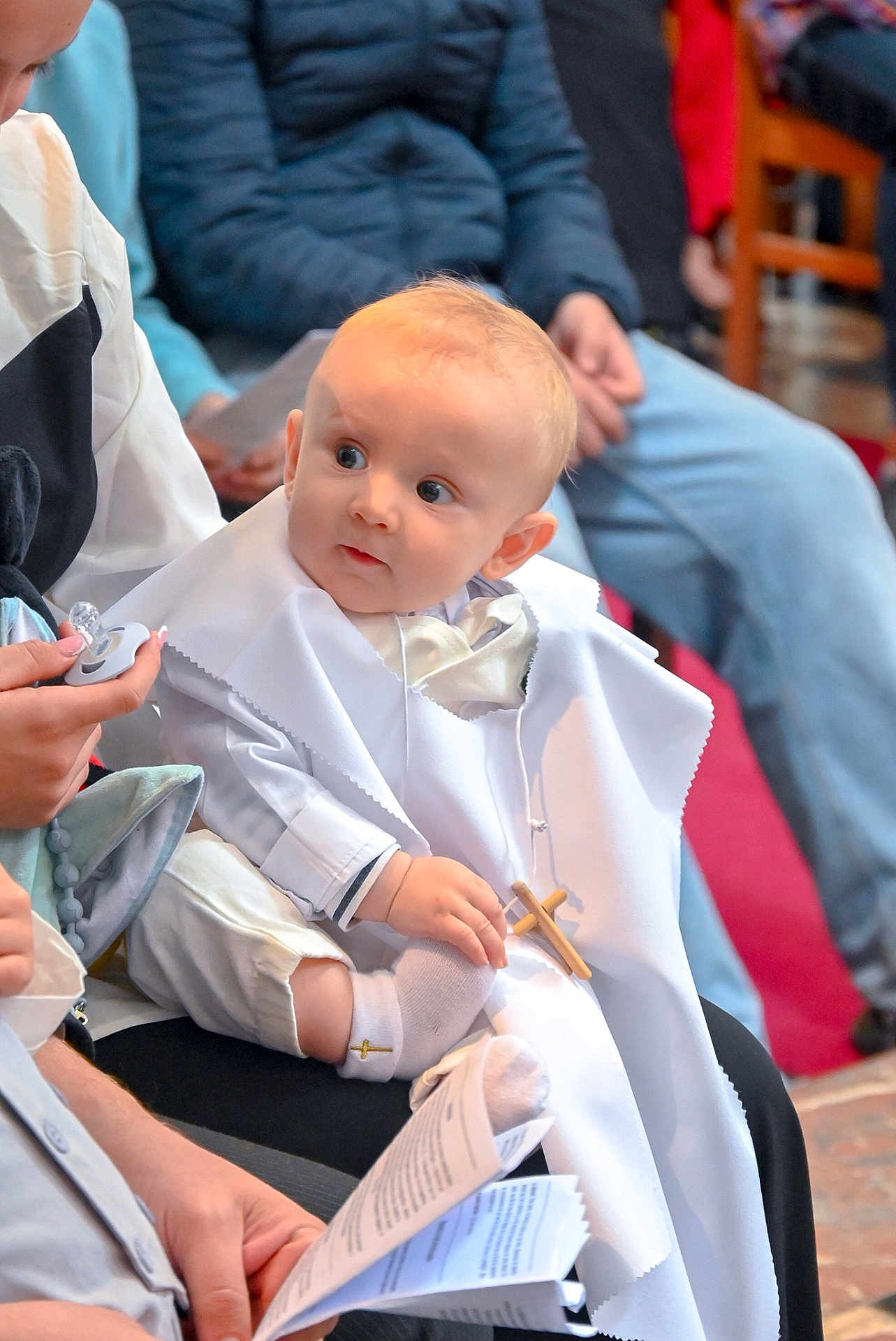 Maneo a rejoint le concours — aidez-le/la à gagner de superbes lots ! baby, child, christening, cross, white_clothing, socks, indoor, people, seated, holding, religious, event, curious, portrait, infant, hands, face, person, paper, background