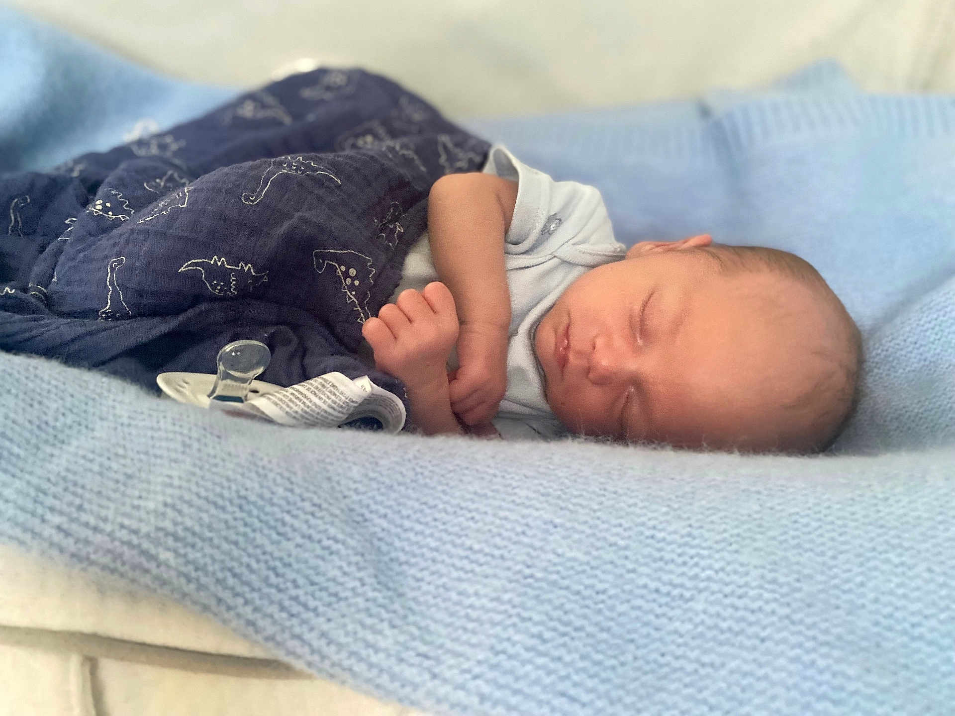 Enzo-John joined the competition — help win amazing prizes! baby, newborn, sleeping, blanket, blue_blanket, pacifier, infant, soft_texture, cute, peaceful, resting, child, portrait, knitted_blanket, wrapped, hand, face, indoors, cozy, dinosaur_print