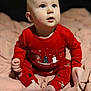 baby, child, infant, red_pajamas, christmas_theme, holiday, sitting, blanket, indoors, cute, portrait, face, feet, hands, blue_eyes, soft_lighting, cozy, winter_clothing, expression, young