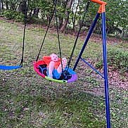 Oliver is registered to the contest to win money with this photo: child, swing, playground, outdoor, grass, trees, greenery, relaxing, leisure, colorful, clothing, footwear, nature, summer, recreation, person, play, backyard, metal_frame, casual