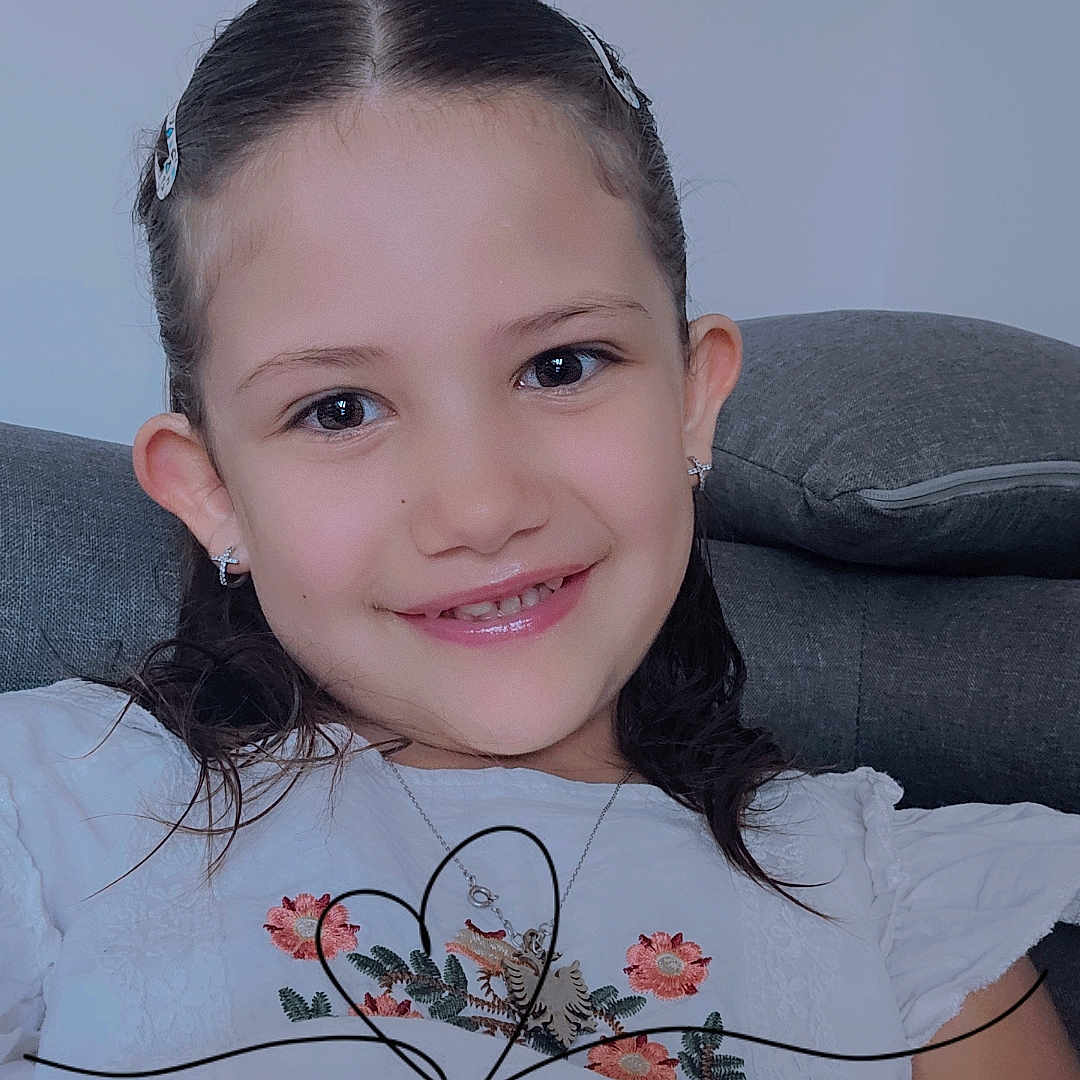 Ines participe au concours pour gagner de l'argent avec cette photo : bodypart, child, clothing, couch, cushion, dress, face, female, finger, formalwear, furniture, girl, hand, happy, head, homedecor, person, photography, portrait, smile