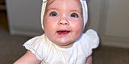 Harlow-Rae joined the competition — help win amazing prizes! apparel, baby, bow, child, cute, expression, eyes, face, fashion, happy, headband, indoor, infant, person, portrait, sitting, skin, smiling, white_dress, young