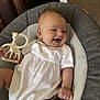 Tommy is registered to the contest to win money with this photo: baby, infant, smiling, white_clothing, giraffe_toy, seat, cushion, happy, child, indoor, person, cute, small_toy, relaxing, portrait, baby_girl, chubby_cheeks, hand, face, comfort