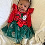 Zalani is registered to the contest to win money with this photo: baby, blanket, bow, child, christmas, cute, dress, footwear, gold_shoes, green_skirt, happy, headband, holiday, indoor, infant, portrait, red_clothing, santa_claus, smiling, white_blanket