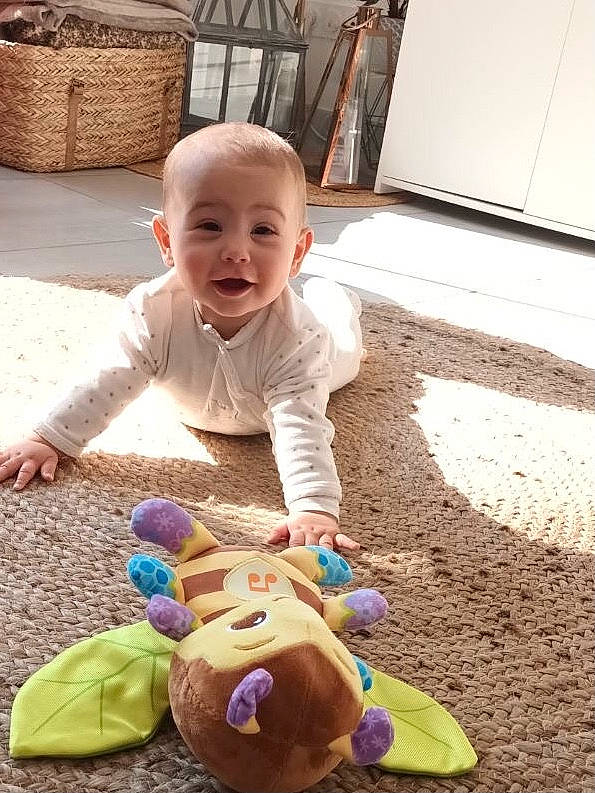 Miléna a rejoint le concours — aidez-le/la à gagner de superbes lots ! baby, baby_toddler_clothing, baby_toys, cheek, child, facial_expression, flooring, fun, grass, happy, head, human, people, person, sitting, skin, smile, stuffed_toy, toddler, toy